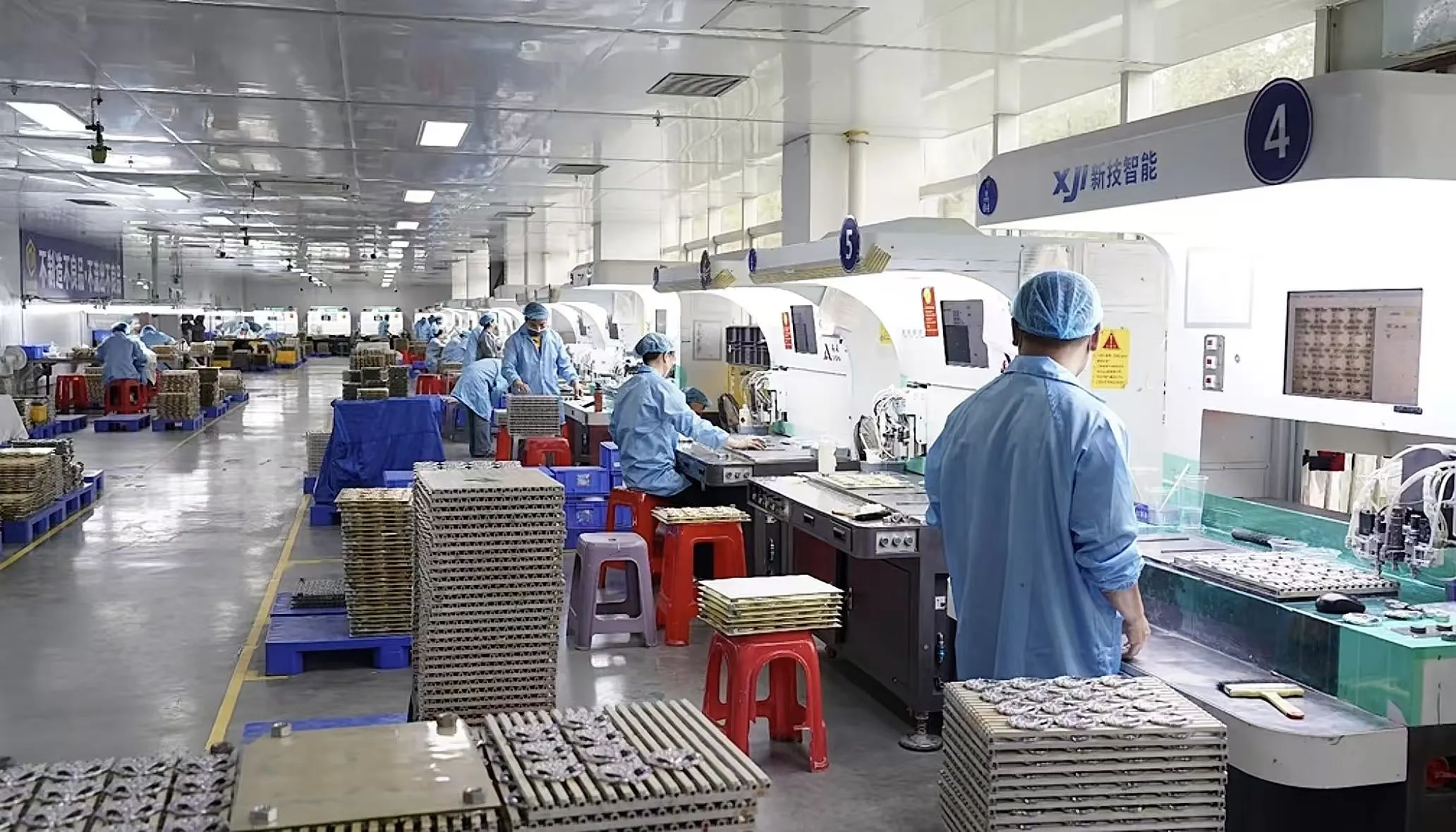 Custom travel souvenir factory with automated production equipment and workers manufacturing personalized travel souvenirs in a modern production facility.