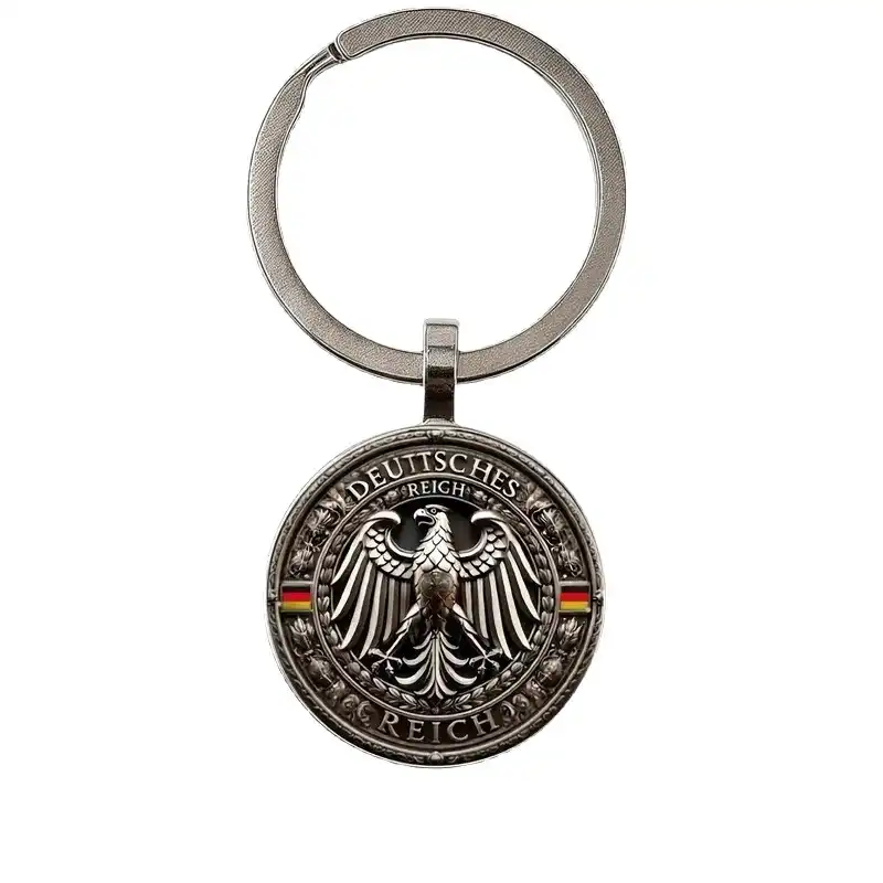 Antique silver-tone round keychain with a raised eagle, DEUTSCHES REICH lettering and small German flag accents