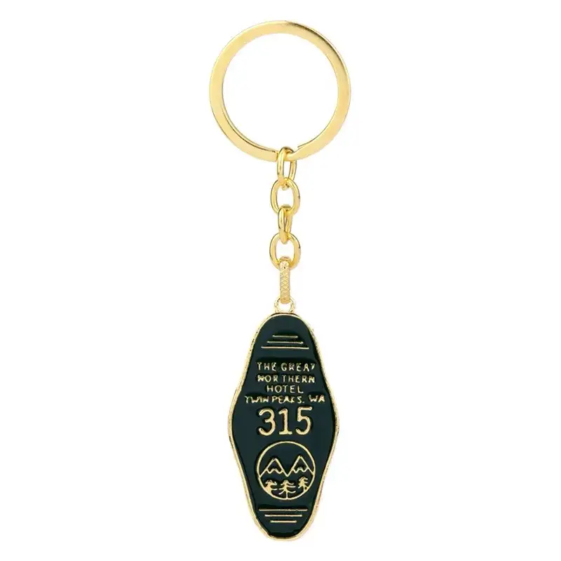 Dark green Great Northern Hotel 315 keychain with gold-tone lettering, mountain and tree design on a white background