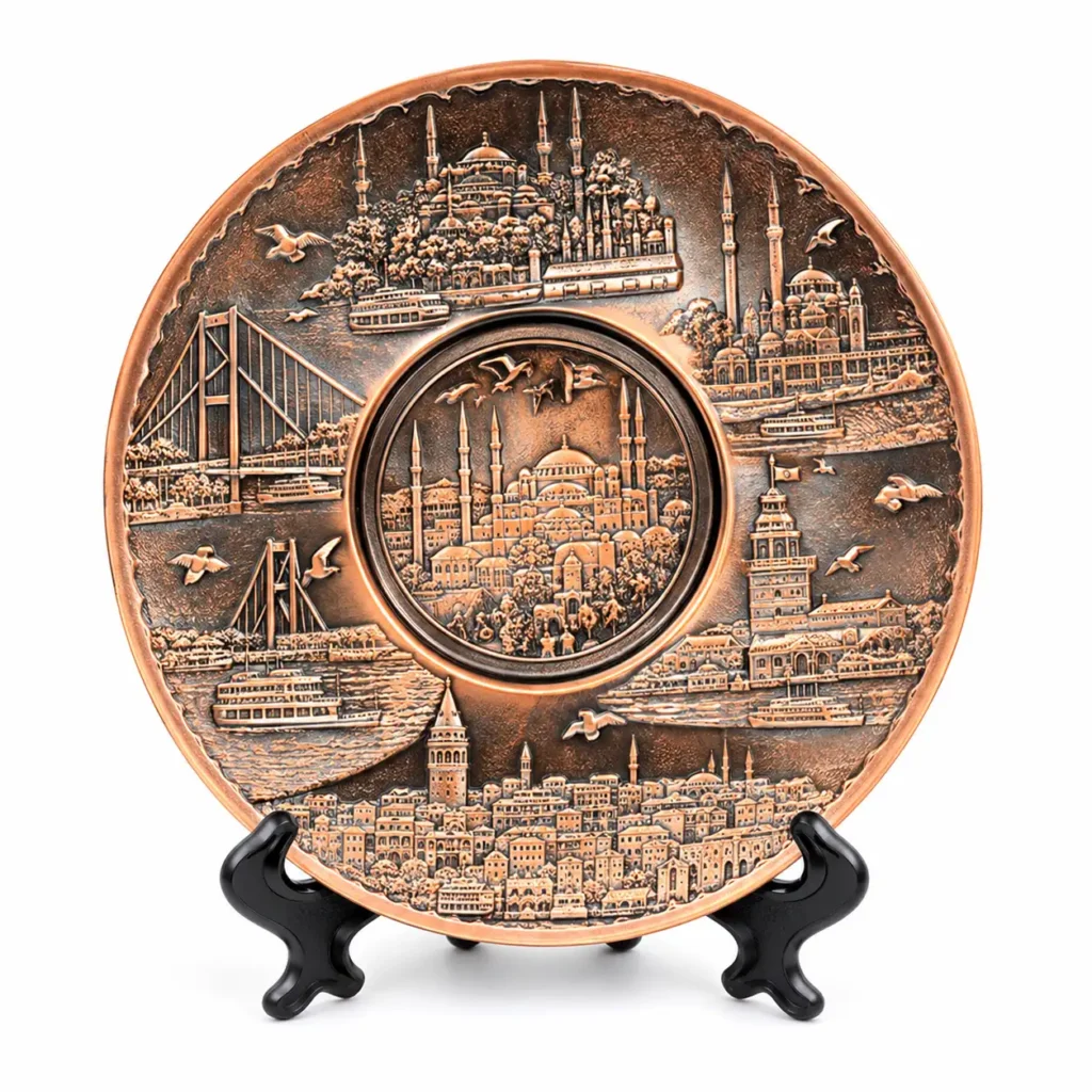 Copper-tone Istanbul souvenir plate with mosque, bridge and waterfront relief on a black stand against a white background
