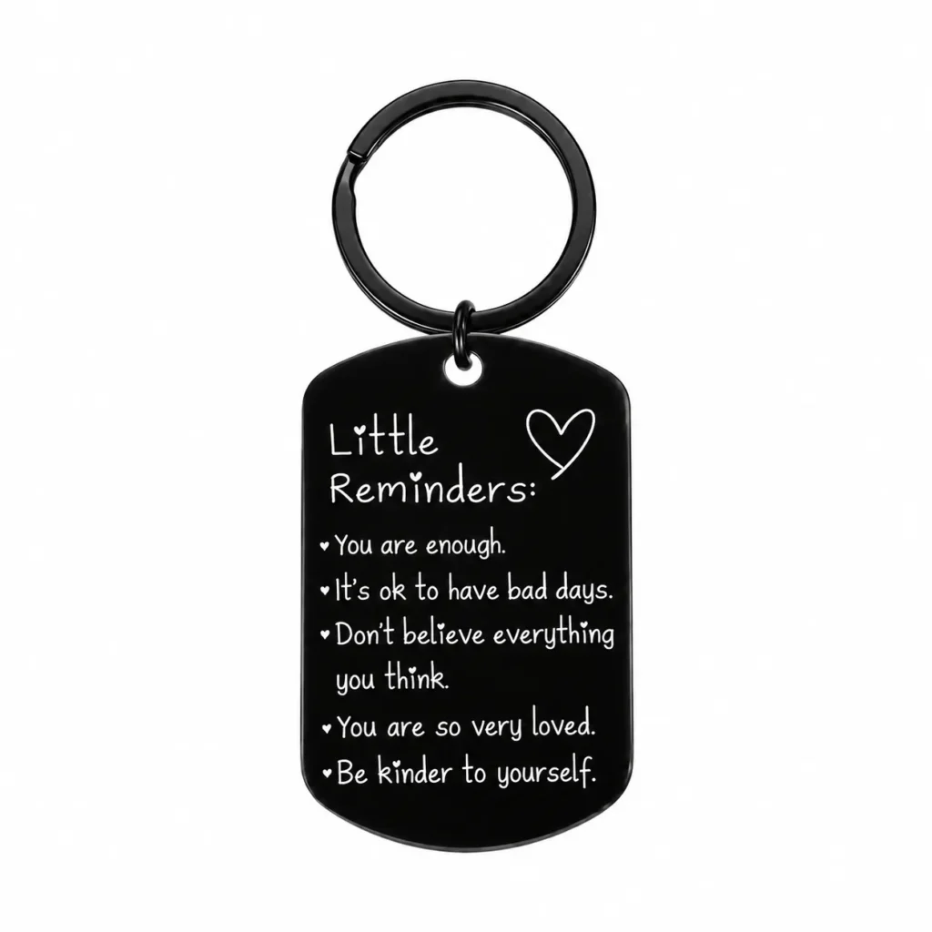 Black tag keychain with white Little Reminders messages and a heart, centered on a white background