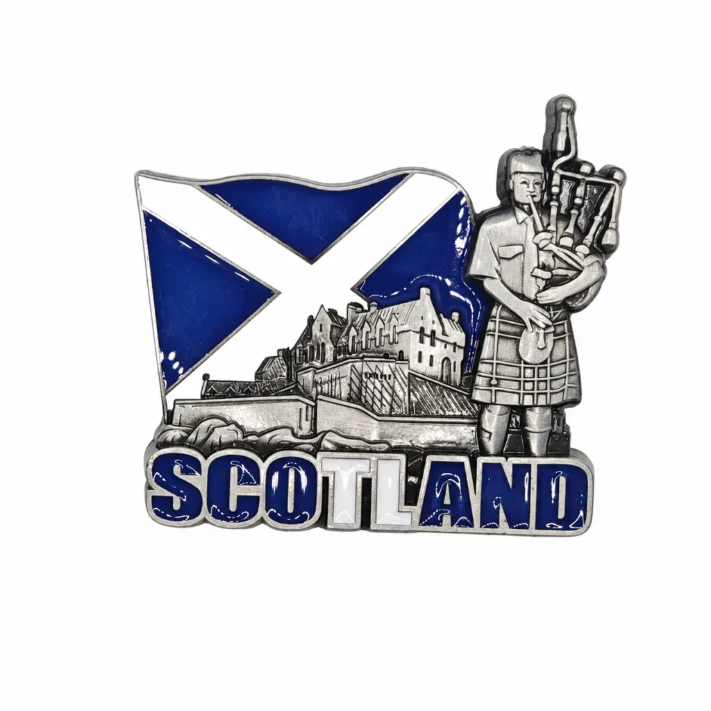 Silver-tone Scotland magnet with blue and white Scottish flag, castle and bagpiper on a white background